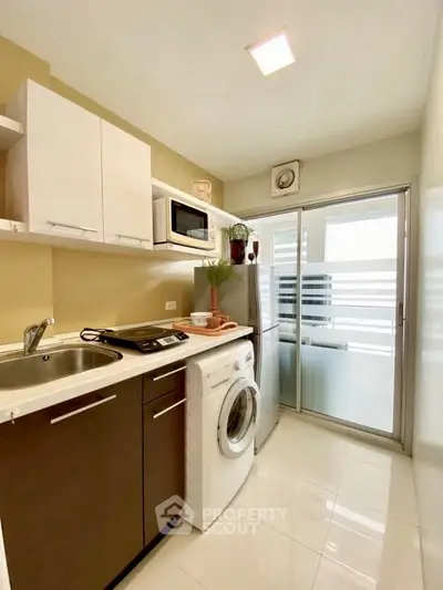 Modern kitchen with washing machine and sleek appliances in compact layout