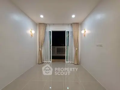 Spacious empty room with elegant lighting and balcony access, perfect for customization.