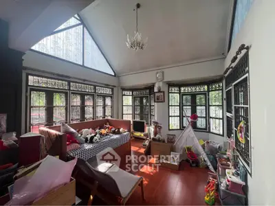 Charming living room with high ceilings, large windows, and abundant natural light, perfect for family gatherings.