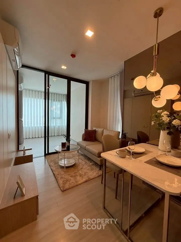 Modern living room with elegant decor and open layout, featuring cozy seating and stylish lighting.