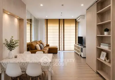 Modern living room with cozy seating and stylish dining area in open layout apartment.