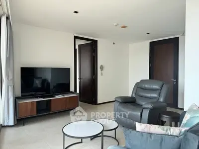 Modern living room with sleek furniture and large TV, perfect for relaxation and entertainment.