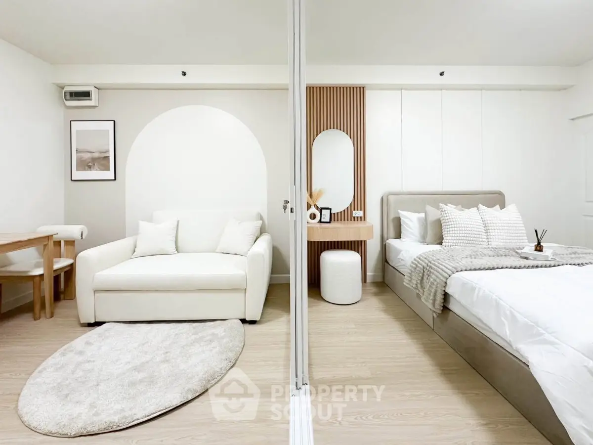 Modern studio apartment with stylish decor, featuring a cozy living area and elegant bedroom setup.
