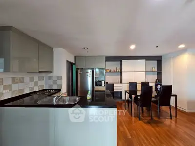 Modern kitchen with sleek dining area and wooden flooring