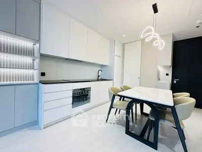 Modern kitchen with sleek white cabinets and elegant dining area