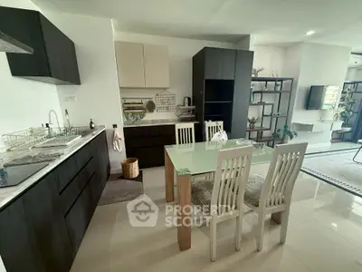Modern kitchen with sleek cabinetry and dining area in open layout