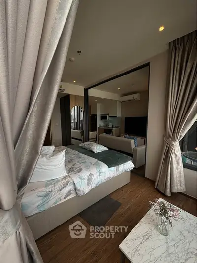 Luxurious open-concept bedroom with modern decor and elegant curtains