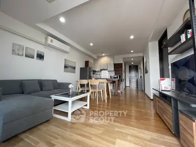 Spacious modern living room with open kitchen and wooden flooring