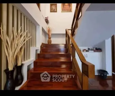 Elegant wooden staircase with decorative vases in a modern home interior