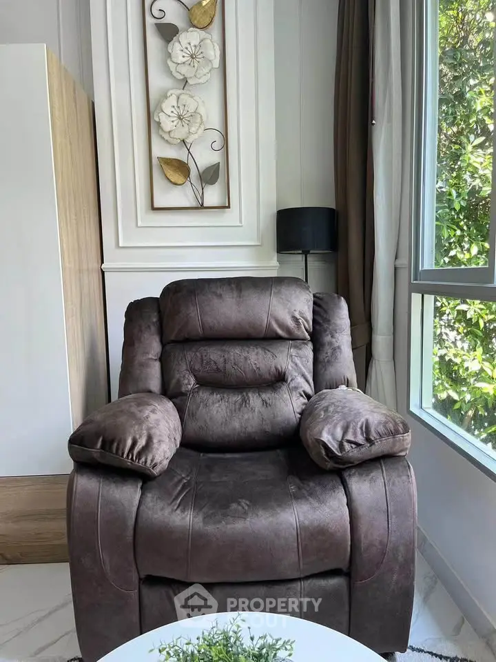 Cozy living room corner with plush armchair and large window view