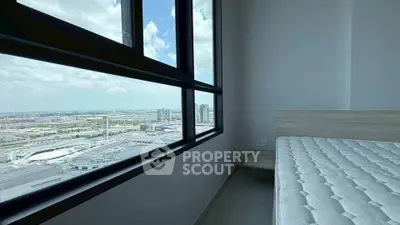 Modern bedroom with panoramic city view and large windows, featuring a minimalist design and ample natural light.