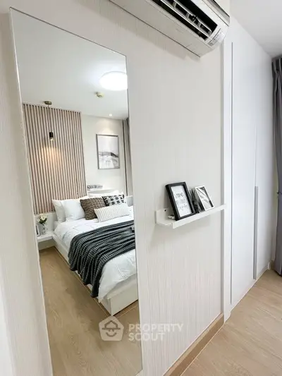 Modern bedroom with stylish decor and air conditioning, featuring a cozy bed and elegant wall art.