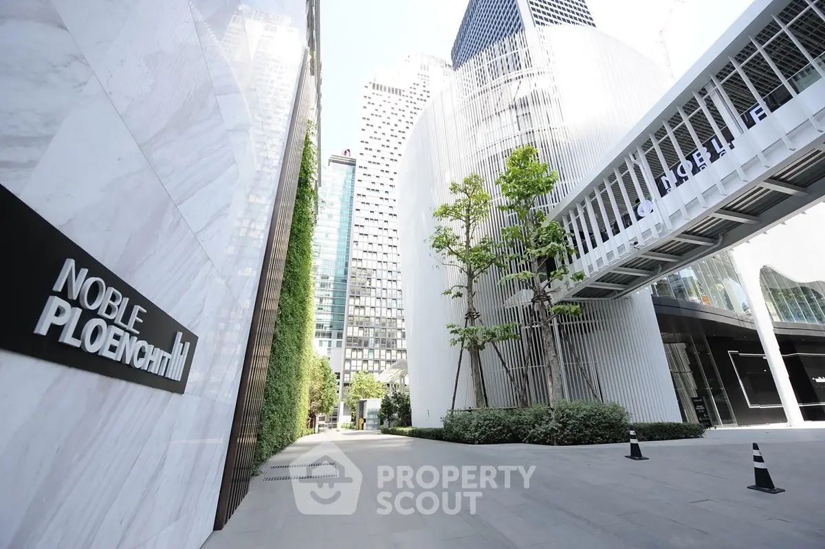 Modern urban building exterior with sleek design and lush greenery in prime city location.