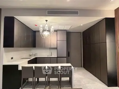 Modern kitchen with sleek cabinetry and elegant chandelier lighting