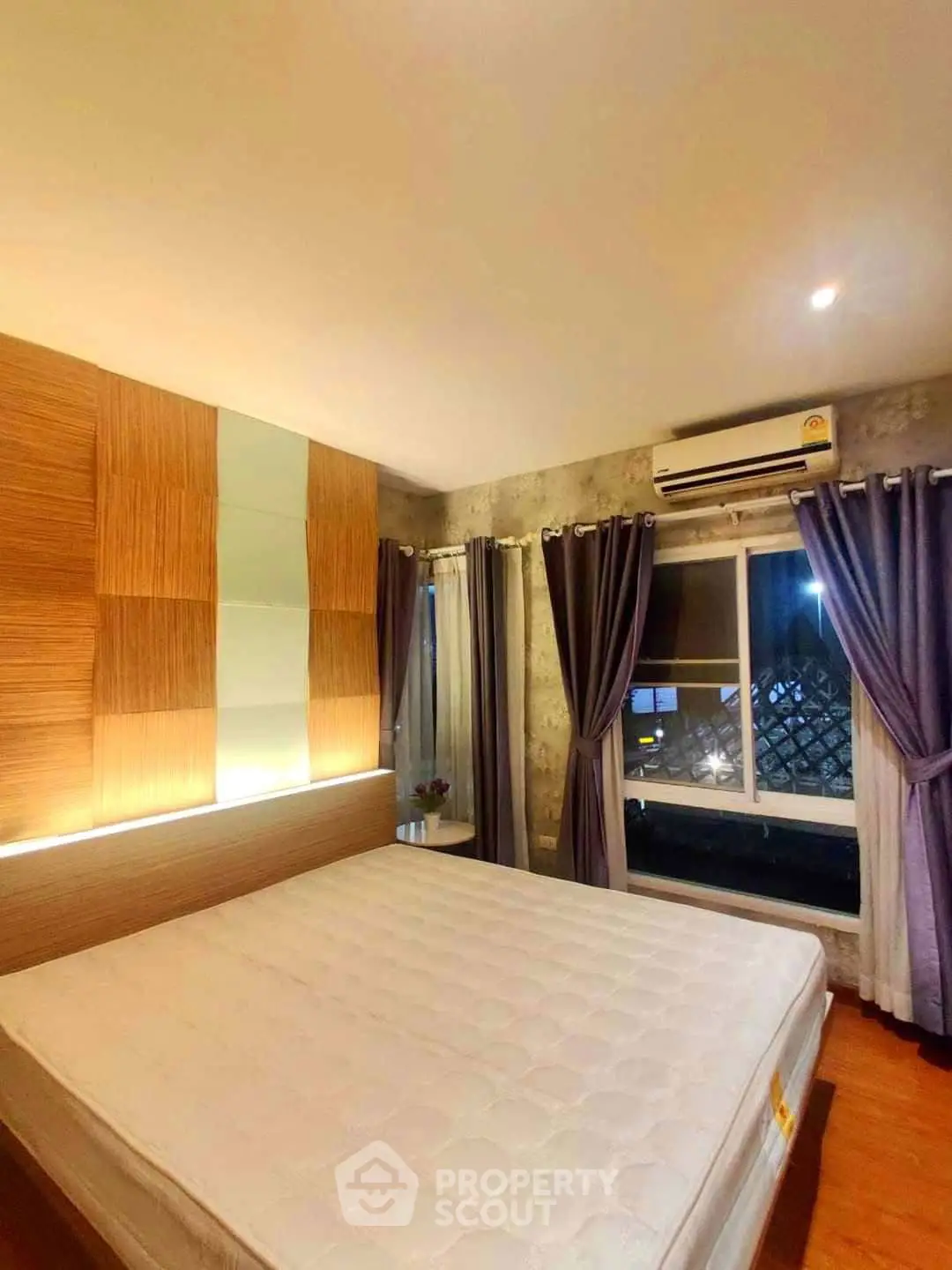 Cozy bedroom with modern design, featuring a large window and stylish curtains.
