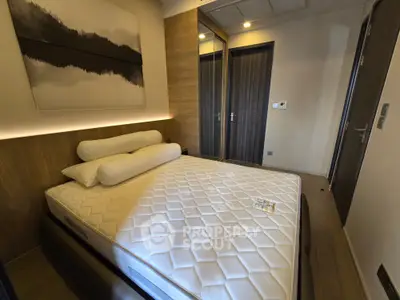 Modern bedroom with stylish decor and mirrored closet doors, featuring a comfortable bed and elegant lighting.