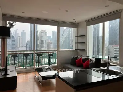 Modern living room with city view and open kitchen layout in high-rise apartment.
