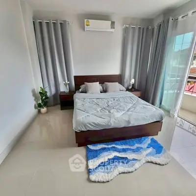 Spacious bedroom with modern decor and large windows for natural light.