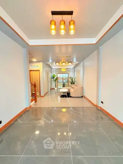 Spacious modern living room with elegant lighting and glossy tiled flooring.