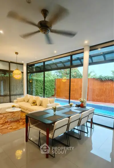 Luxurious living room with pool view, modern furniture, and elegant lighting in a stylish home.