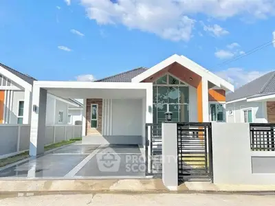 Modern single-story house with sleek design and spacious driveway under clear blue sky.