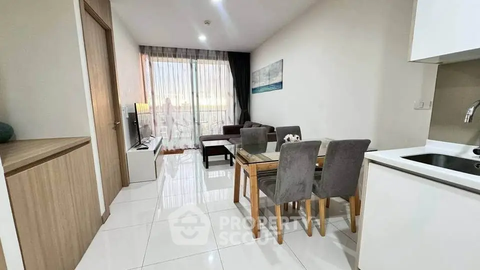 Modern living room with dining area and balcony view in stylish apartment.