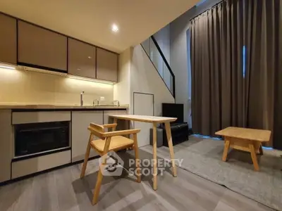 Modern loft-style living room with open kitchen and stylish wooden furniture.