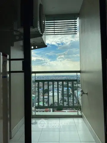 Stunning city view from a high-rise balcony with clear skies and urban landscape.