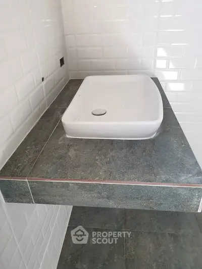 Modern bathroom sink with sleek tile design and contemporary style.