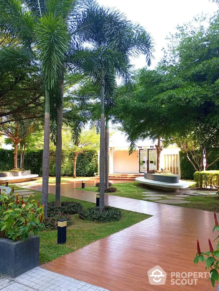 Lush garden with palm trees and paved walkway in serene residential setting