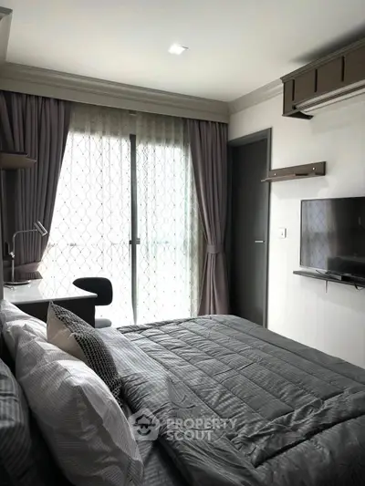 Modern bedroom with sleek design, featuring a cozy bed, wall-mounted TV, and a work desk by the window.