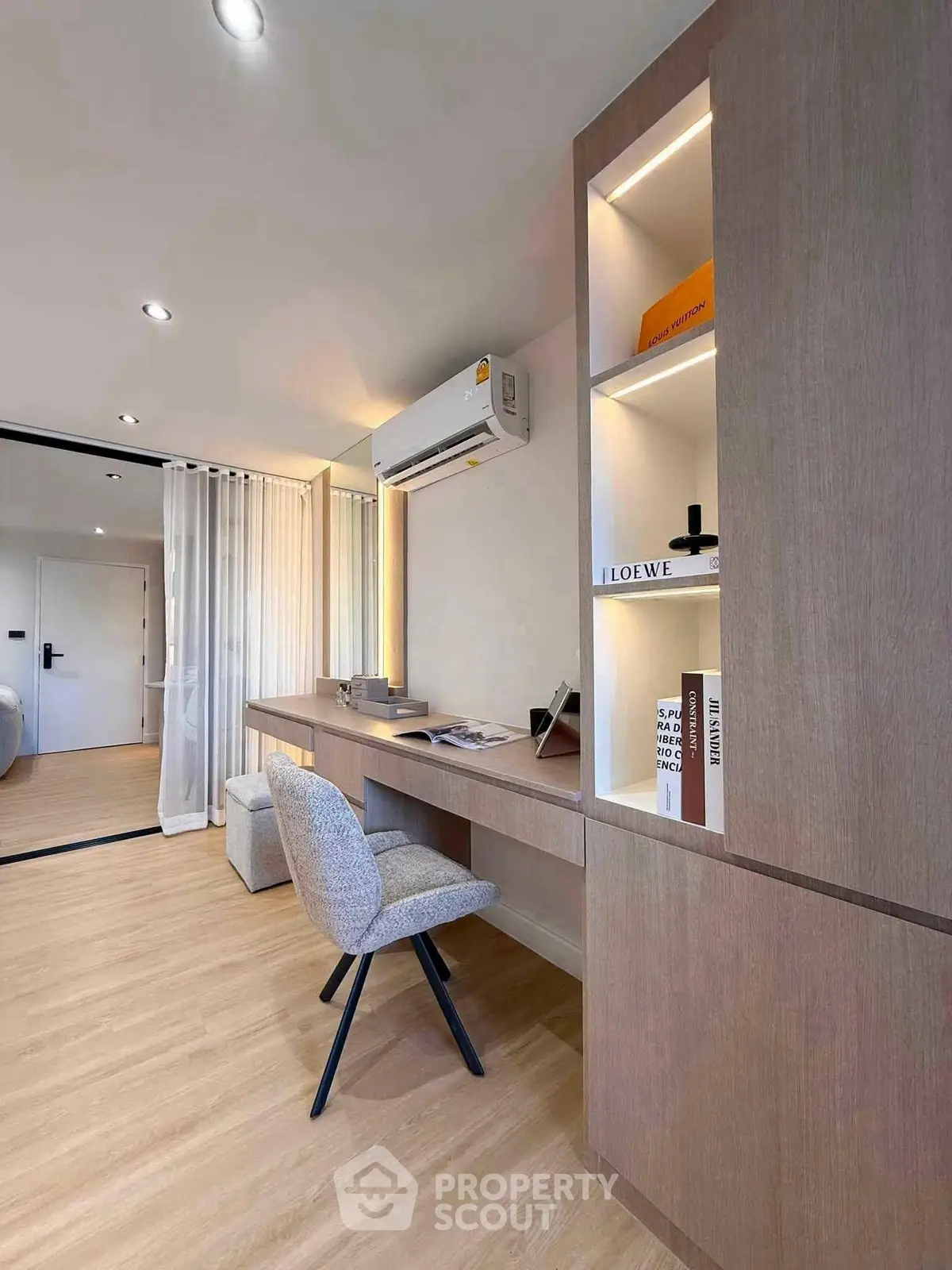 Modern study room with built-in desk and shelves, featuring elegant lighting and contemporary decor.