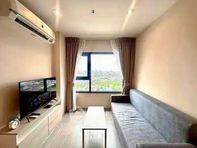 Modern living room with city view, featuring sleek furniture and natural light.