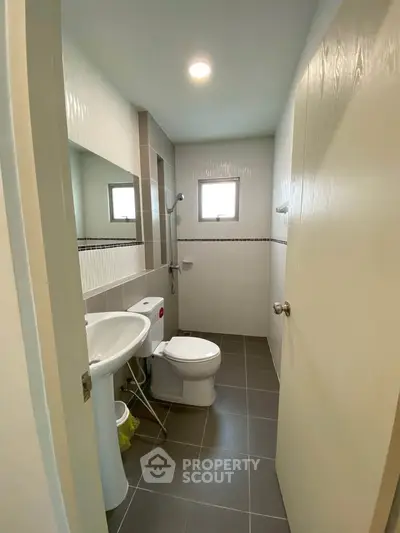 Modern bathroom with sleek design, featuring a compact layout and contemporary fixtures.