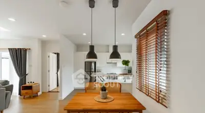Modern dining area with stylish lighting and open kitchen layout in a contemporary home.