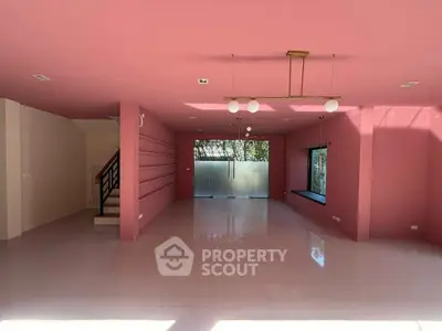 Spacious pink-themed living room with modern lighting and large windows