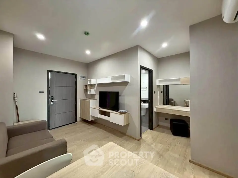 Modern living room with sleek furniture and built-in TV unit in a stylish apartment.