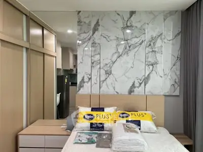 Modern bedroom with marble accent wall and sleek storage solutions.