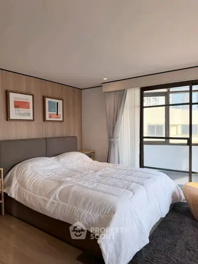 Cozy bedroom with large window and modern decor in a stylish apartment.