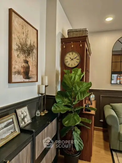 Charming living room with elegant decor, featuring a classic clock and lush indoor plant.