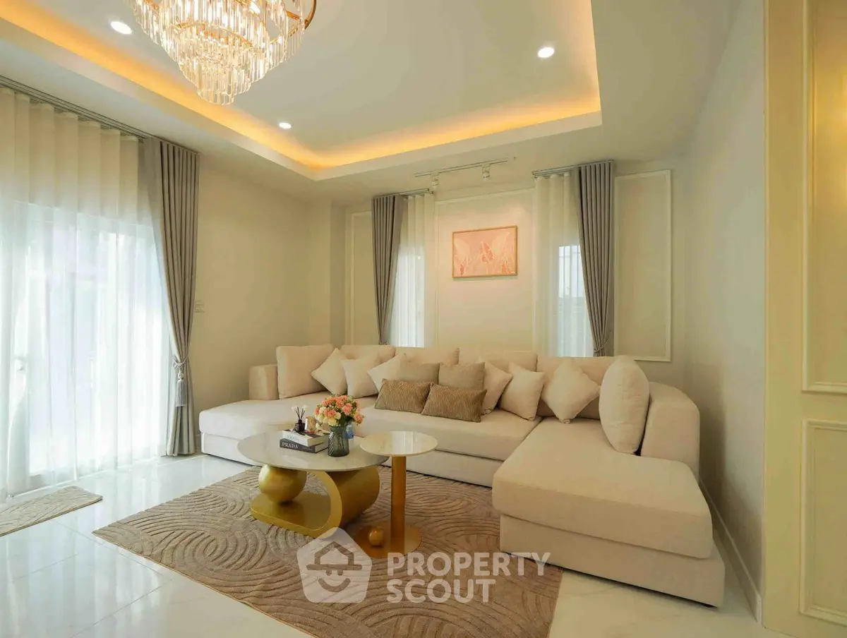 Luxurious living room with elegant chandelier and plush sectional sofa in a modern home.
