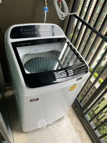 Modern washing machine on a high-rise balcony with city view