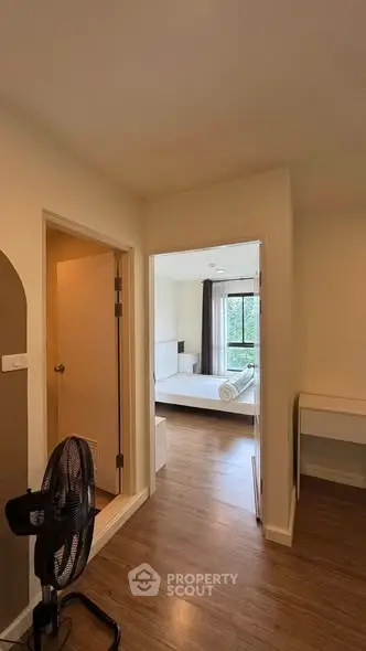 Spacious bedroom with wooden flooring and natural light, featuring a cozy study nook.