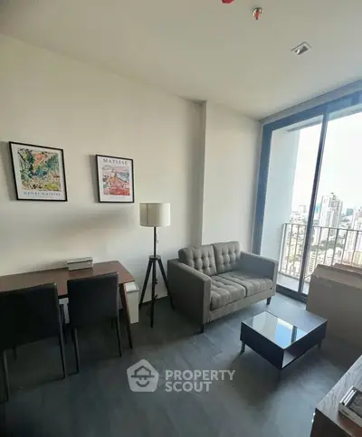 Modern living room with city view, featuring stylish furniture and floor-to-ceiling windows.
