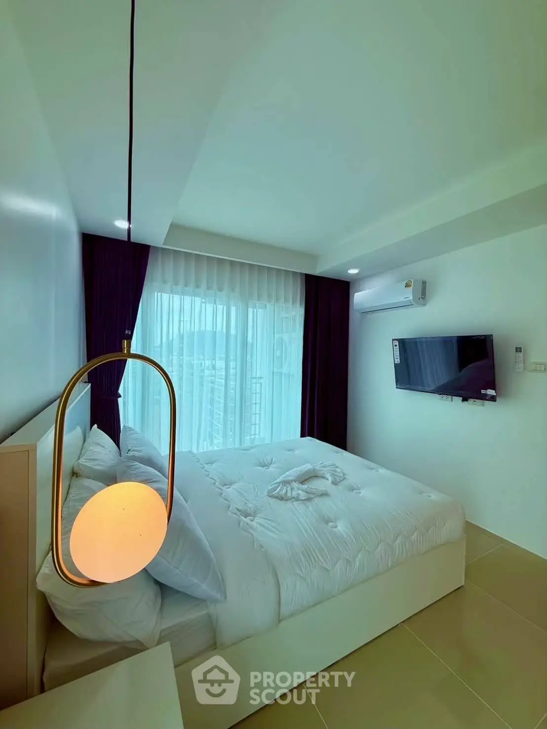 Modern bedroom with stylish lighting and large window offering natural light.