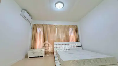 Spacious bedroom with natural light and minimalist decor, featuring a comfortable bed and air conditioning.