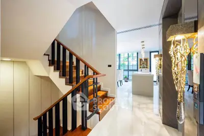 Luxurious modern interior with elegant staircase and open living space, featuring stylish lighting and sleek design.