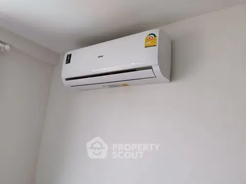 Modern wall-mounted air conditioning unit in a minimalist interior setting.