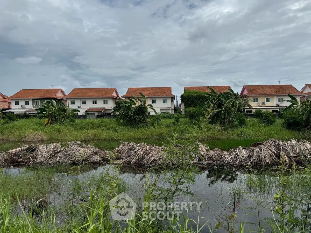 Charming suburban homes with red roofs and lush greenery in a serene neighborhood setting.