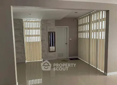 Spacious interior with modern vertical blinds and glossy tiled flooring, ideal for versatile living space.